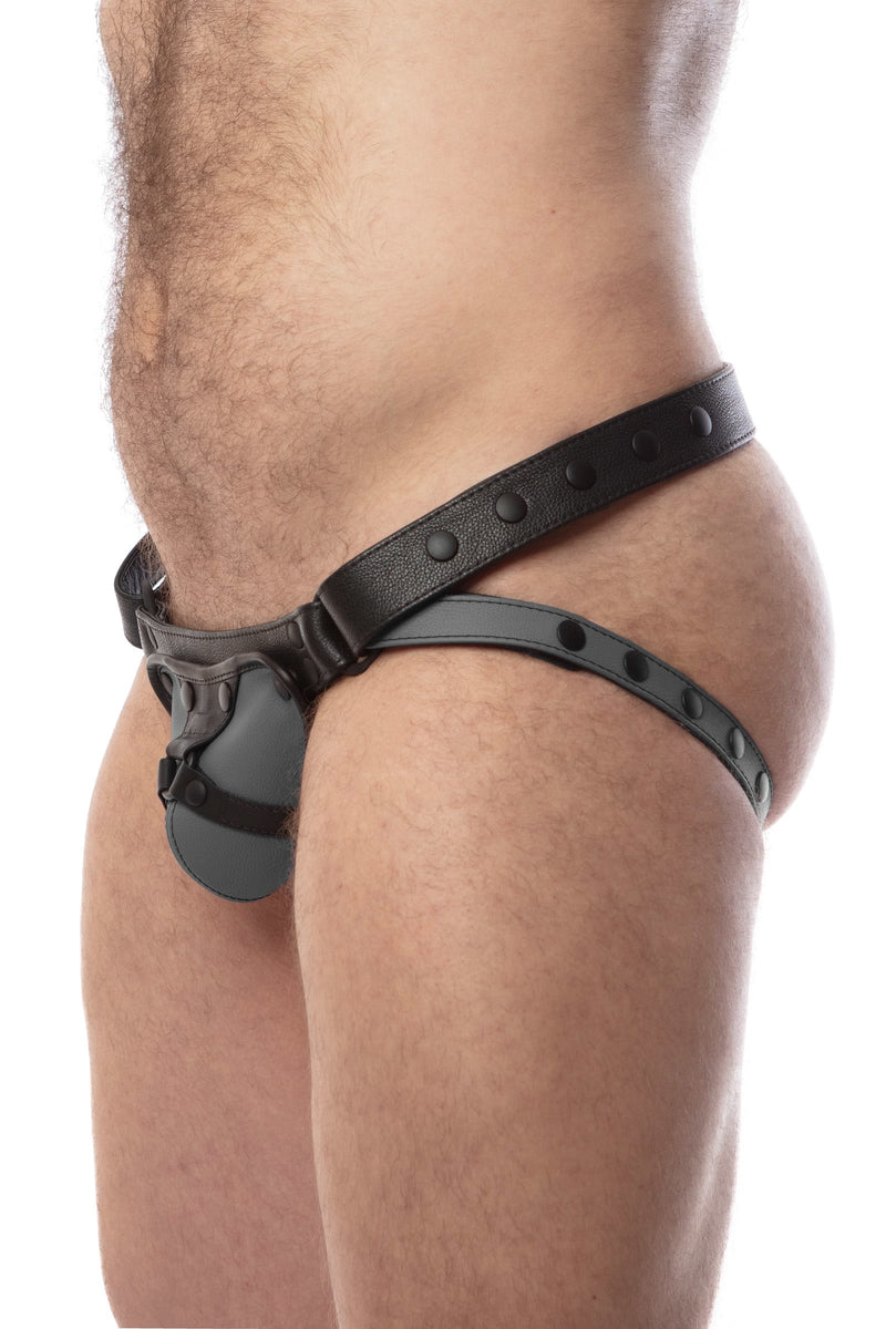 Side view of model wearing a black and grey leather jockstrap with harness detail on codpiece