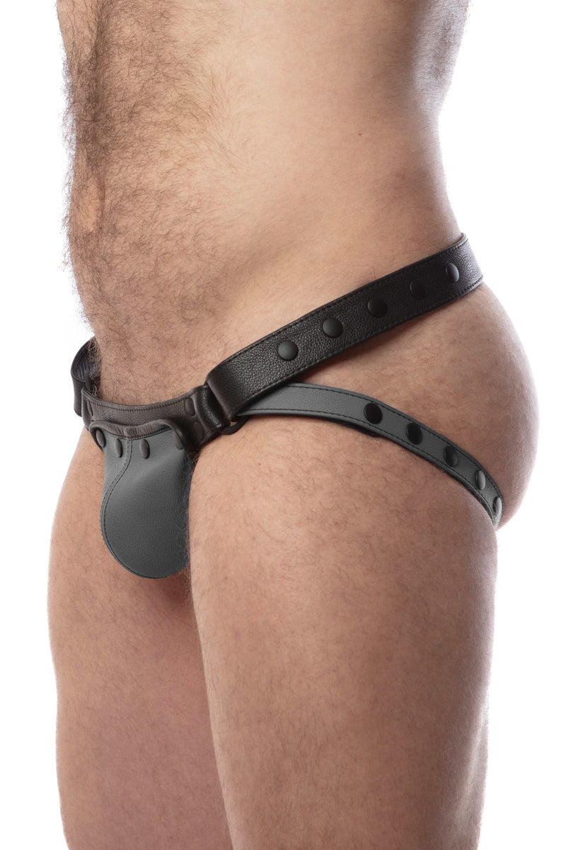 Side view of model wearing a black and grey leather jockstrap with matching coloured codpiece