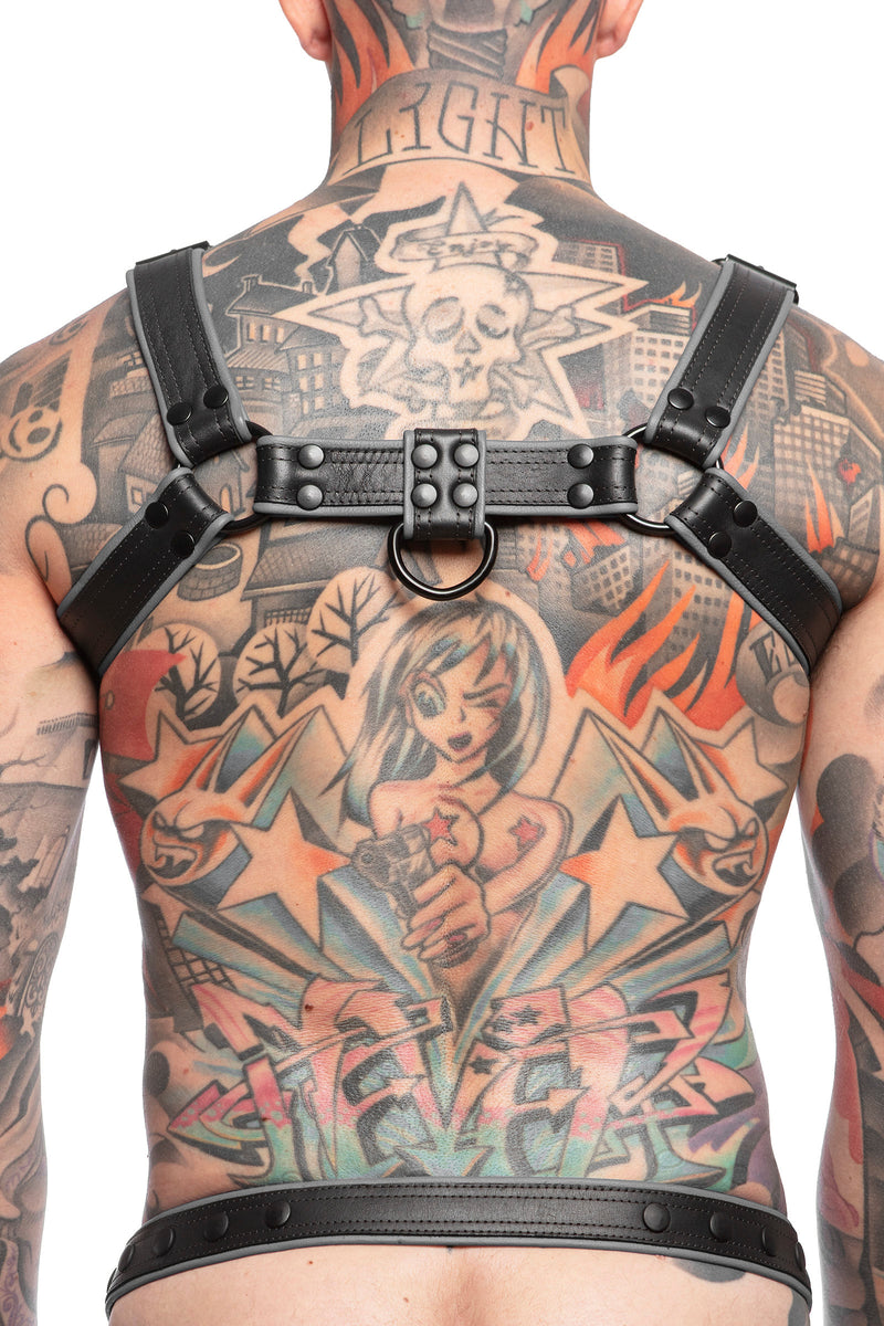 Model wearing black and grey leather combat bulldog harness with matt black metal hardware. Back view.