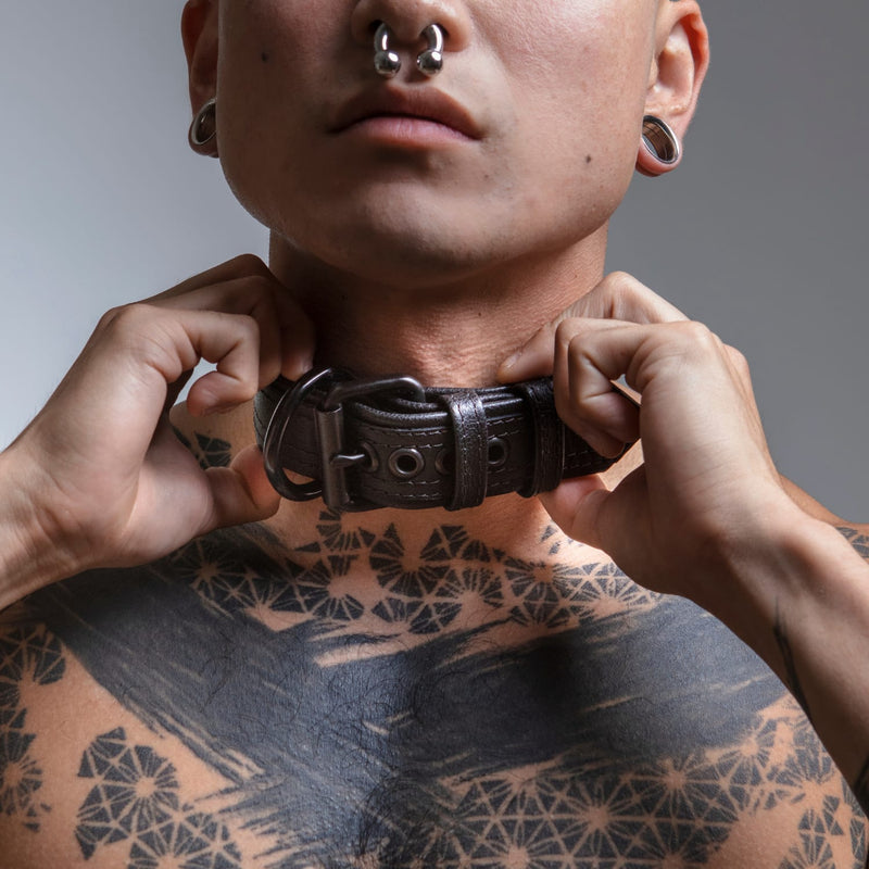 Model fitting a leather neck collar on his own neck