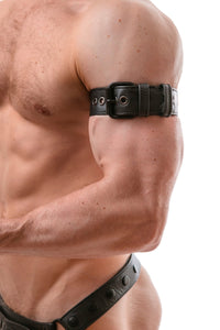Close-up side view of a model wearing a 1.5" wide black leather buckled armband with matte black hardware.