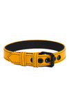 A 1" wide yellow leather buckled armband with matte black hardware, in a coil.