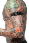 Side close-up of a tattooed model showing a 1" wide black and grey leather armband with matte black hardware.