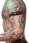 Profile close-up showing a model in a black and yellow leather armbelt detailed with matte black hardware.