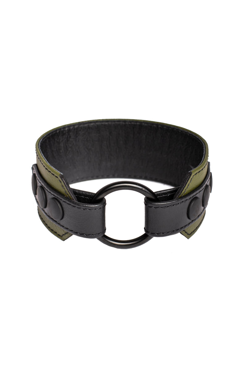 An army green and black leather armband with matte black components, coiled into a loop.