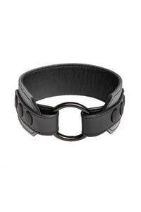 A 2" wide grey and black leather armband with matte black hardware, in a coil.