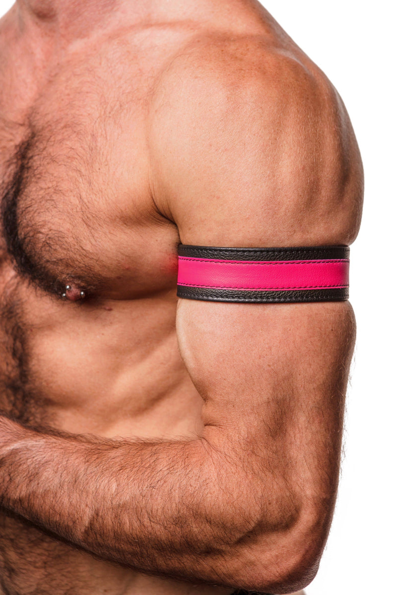 Zoomed side shot showing a model styled in a 1.5" wide black and fluro pink leather armband with matte black hardware.
