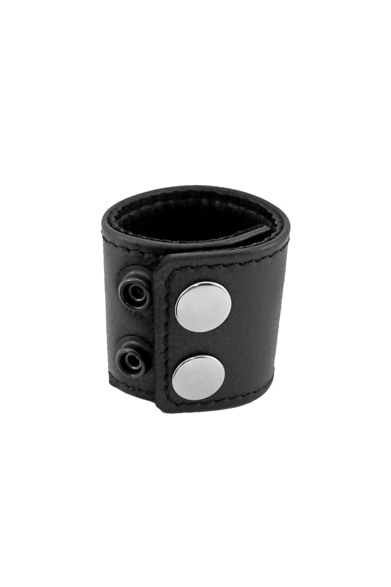 A 2" wide ARMY OF MEN black leather ball stretcher, coiled to display stainless steel snaps.