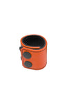 An orange leather ball stretcher with matte black snaps, looped into a ring.