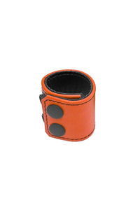 An orange leather ball stretcher with matte black snaps, looped into a ring.