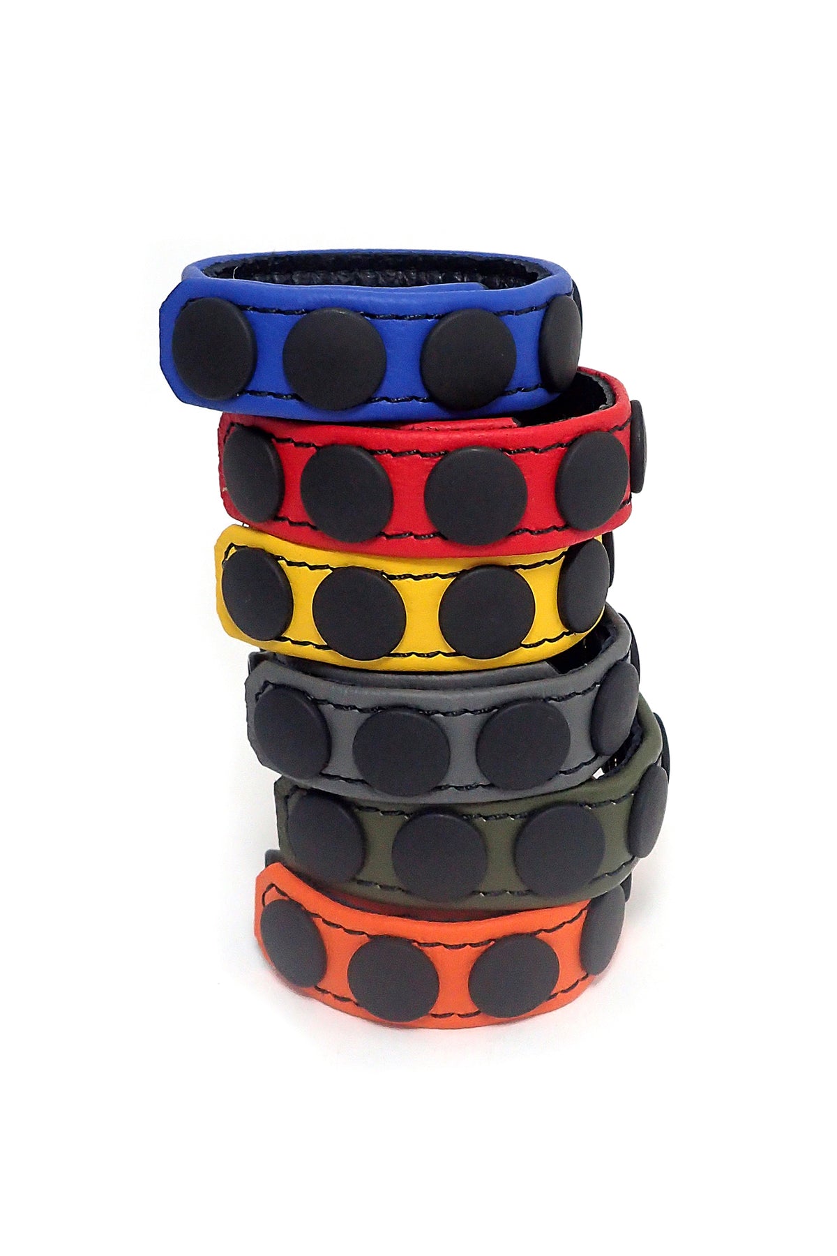 Coiled display of six 3/4" wide coloured leather cockrings detailed with matte black hardware.