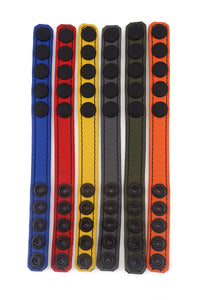 Front-facing view of six coloured leather cockrings highlighting the matte black snaps.