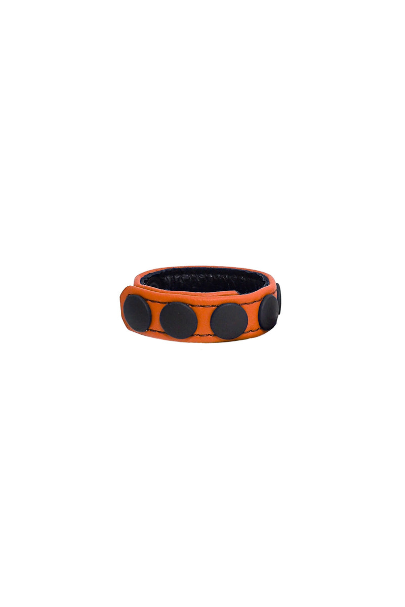 A curled orange leather cockring with matte black components.