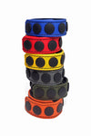 Six 1" wide coloured leather cockrings with matte black hardware, stacked in coils.