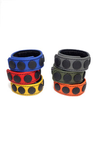 Six coloured leather cockrings finished with matte black components, in two stacks.