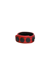 A 1" wide red leather cockring with matte black hardware, in a coil.
