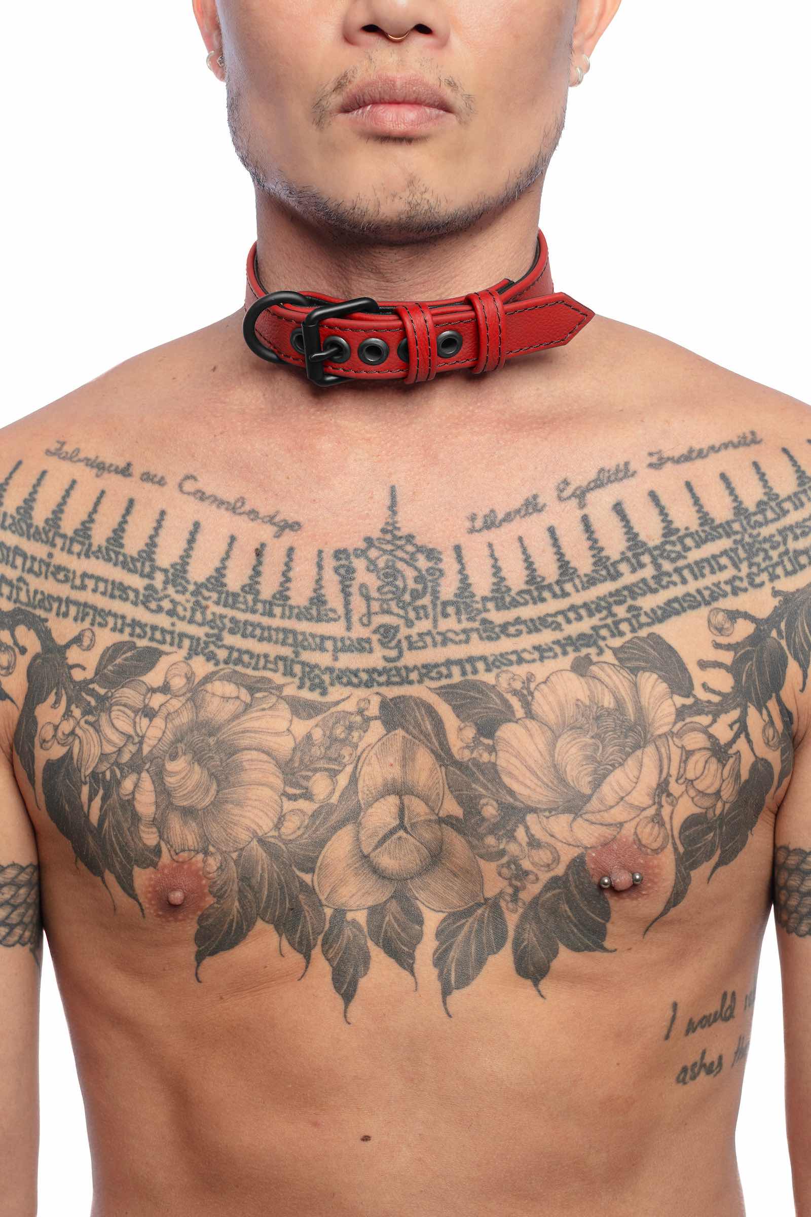 A tattooed model wearing a 1" wide CLASSIC COLLAR NARROW - Red with matte black rivets, buckle, and D-ring. 