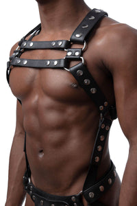 Male model in three-quarter pose wearing a leather Full Universal X Kit with stainless steel O-rings. Front straps parallel.