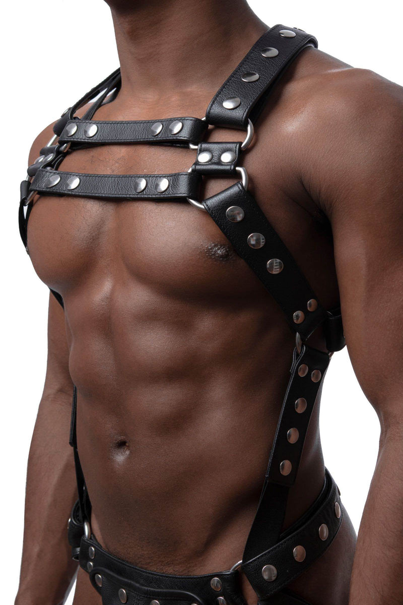 Male model in three-quarter pose wearing a leather Full Universal X Kit with stainless steel O-rings. Front straps parallel.