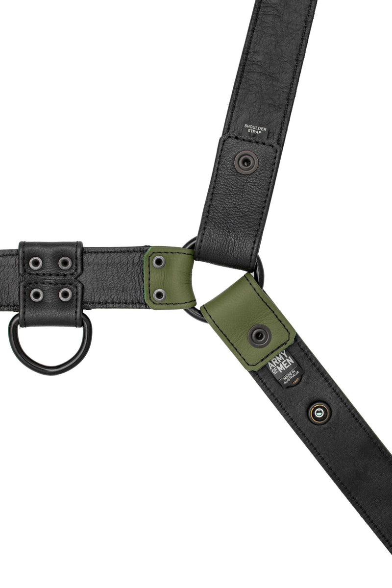 A 1.5" wide ARMY OF MEN black and army green leather harness with matte black hardware, laid flat and displaying the lining.