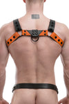 A chiselled model in an ARMY OF MEN CHEVRON BULLDOG - Orange with matte black rivets, snaps, O-rings, and D-rings, back view.