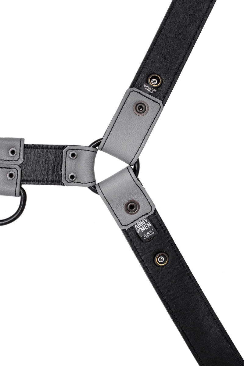 ARMY OF MEN 1.5" wide grey leather chest harness with matte black rivets, laid flat and showing the lining leather.