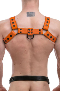 A ginger haired model turned away wearing a 1.5" wide ARMY OF MEN orange leather chest harness with matte black hardware.
