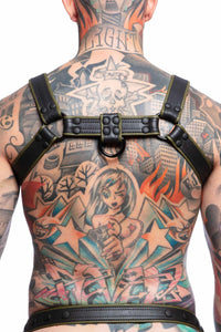 A toned model turned away wearing an ARMY OF MEN COMBAT BULLDOG - Army Green with matte black rivets, buckles, and D-rings.