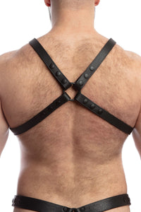 A hairy model seen from behind wearing a 1" wide ARMY OF MEN black leather x-style harness with matte black hardware.