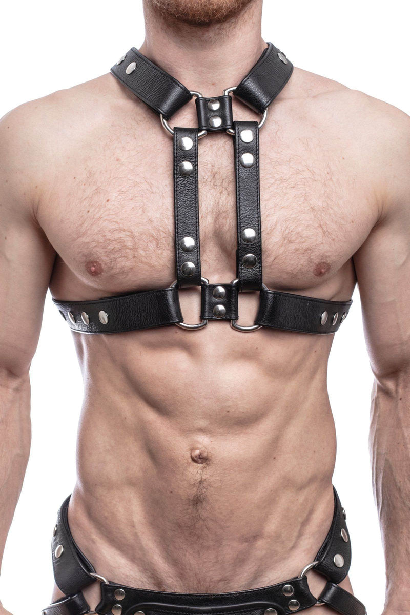 ARMY OF MEN black leather chest harness with stainless steel rivets styled on a male model, facing forward.