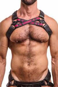 Toned male model in an ARMY OF MEN UNIVERSAL X HARNESS - Fluro Pink with matte black hardware. Front straps crossed.