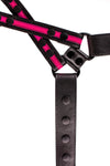 Overhead view of an ARMY OF MEN black and fluro pink leather harness with matte black rivets, snaps, and D-rings.