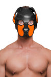Shot from the chest up, the toned model is wearing a handcrafted leather pup hood, with fluorescent orange ears and snout.