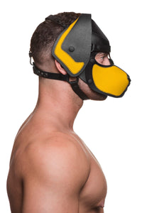 Pictured from the side, a bare-chested male model wears a handmade leather ARMY OF MEN pup hood, with yellow snout and ears.