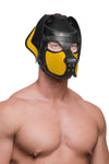 Fit male model in a quality black and yellow leather pup hood, with durable matte black hardware, looking off to the right.