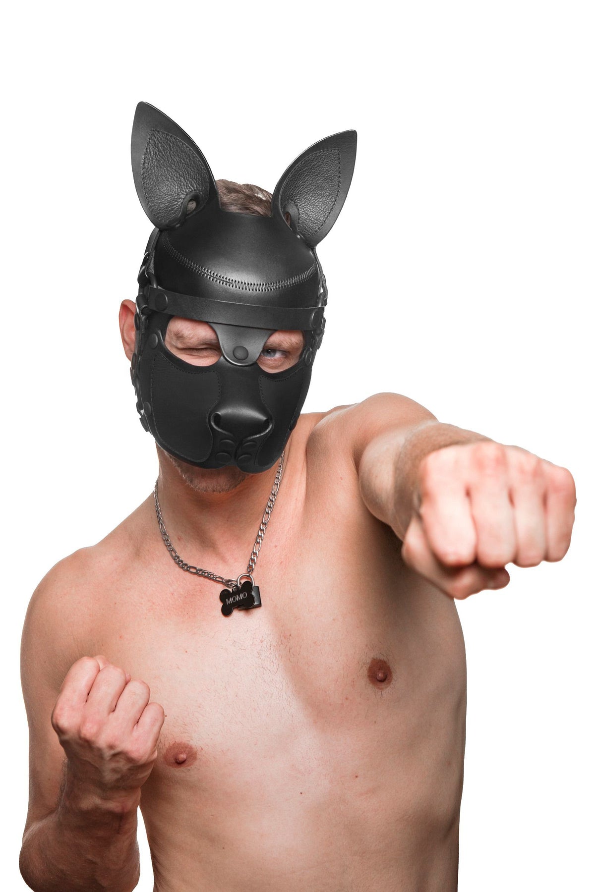 POW! Cheeky shirtless model in a black all leather SCOUT pup hood punches his left fist in the air.