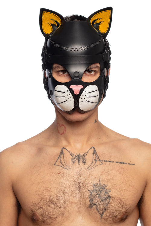 Front view of a model styled in an ARMY OF MEN black leather cat hood, with yellow ears, white whisker pads and a pink nose.