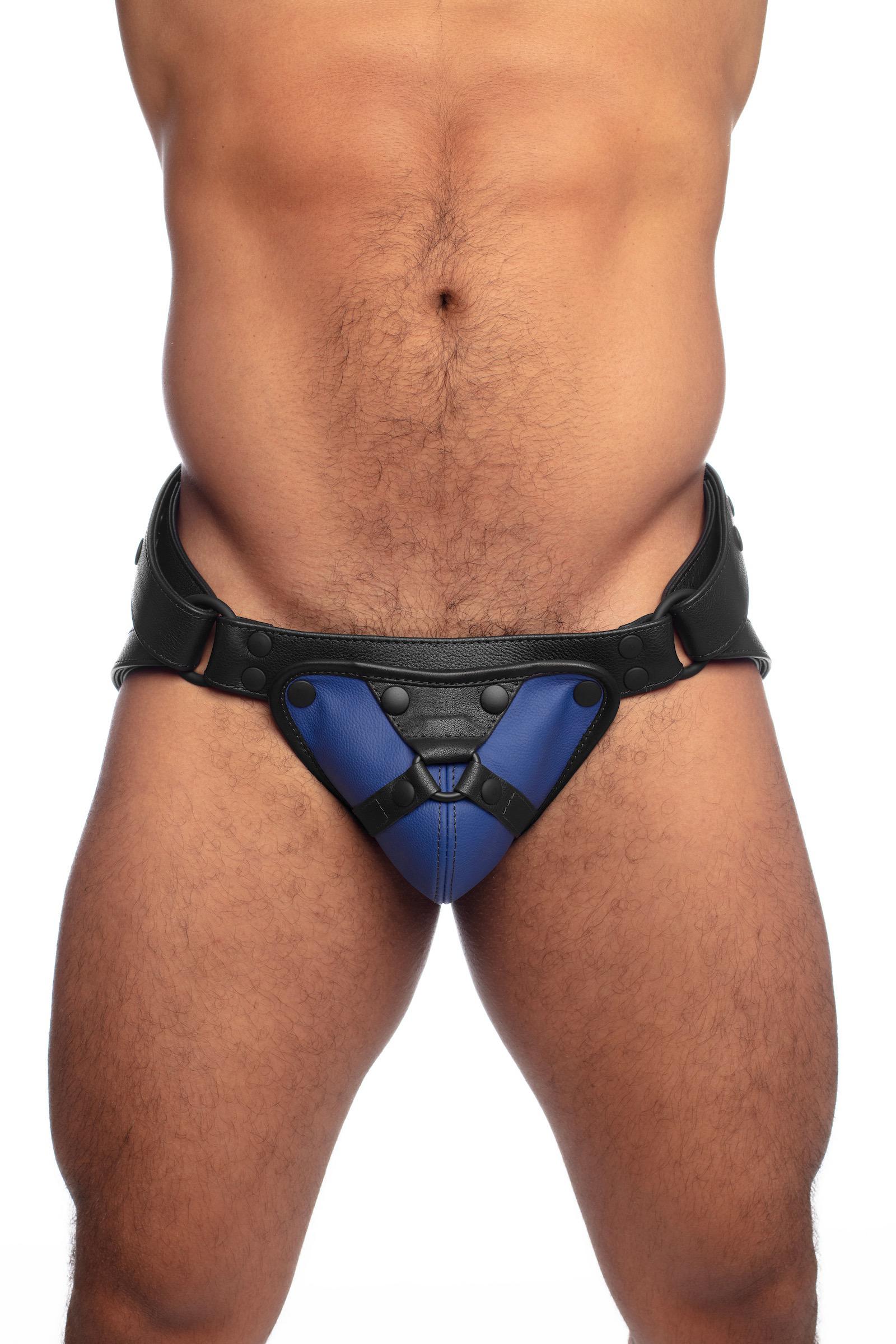 Front view of a model in a black and blue leather jock with harness detailed codpiece.