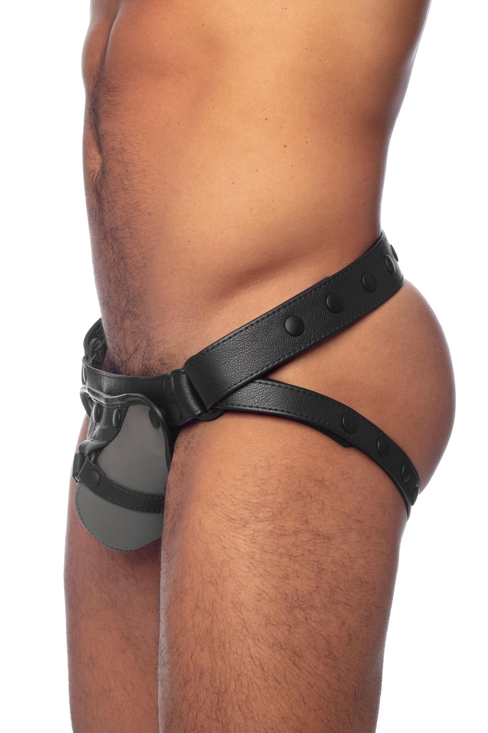 Side view of a model in an grey and black leather jockstrap with detectable codpiece.