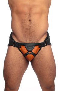 Muscular model in an ARMY OF MEN black and orange leather harness jockstrap.