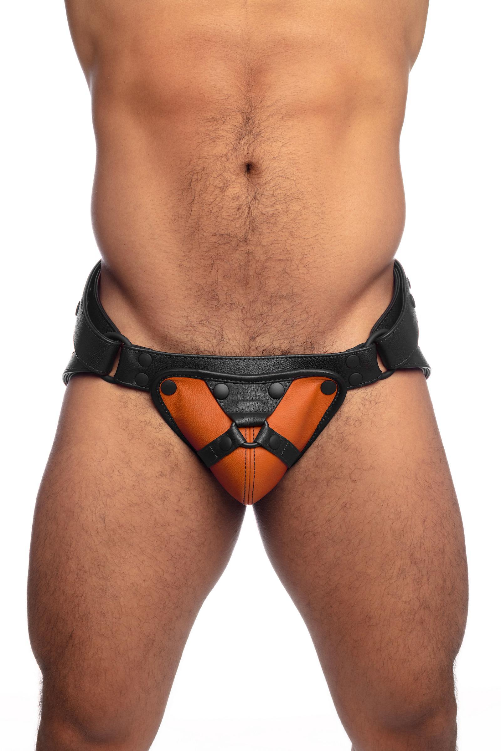 Muscular model in an ARMY OF MEN black and orange leather harness jockstrap.