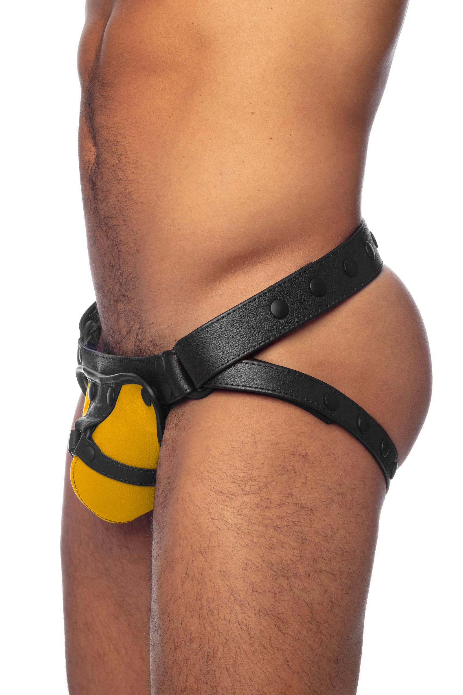Bulging model in an ARMY OF MEN black and yellow leather jockstrap. Side view.