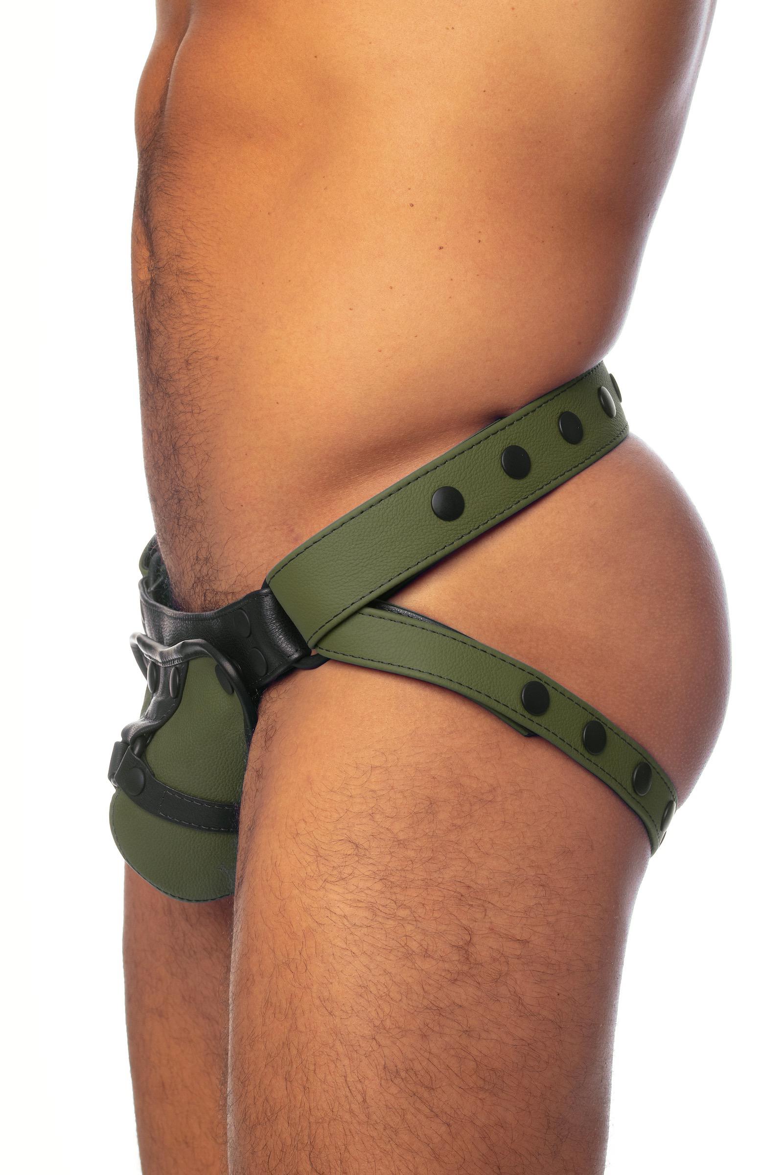Side view of a male model in an army green and black leather jockstrap. 