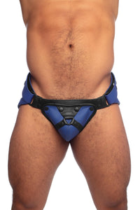 Front view of a muscular male model in a blue and black harness jockstrap.