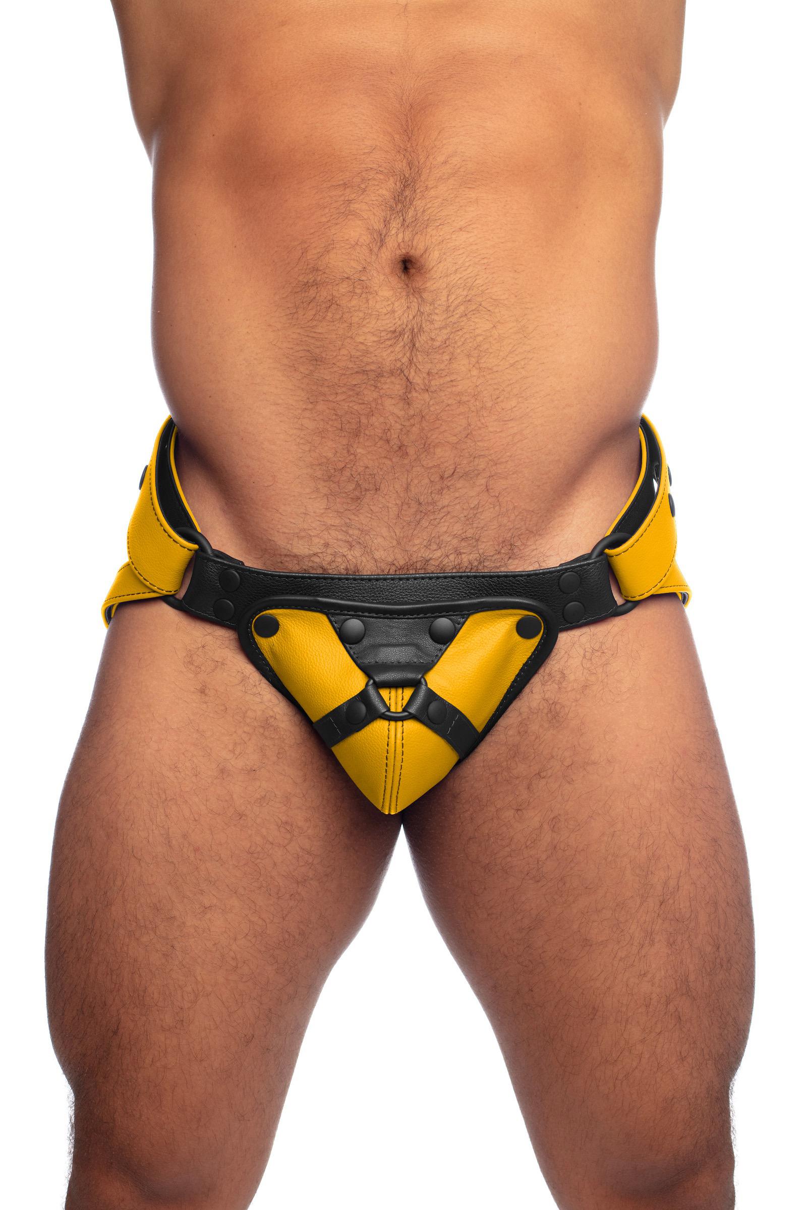 Thick model in an ARMY OF MEN yellow and black leather jockstrap. Front view.