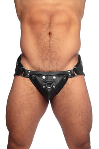 Model wearing a black leather harness jockstrap with stainless steel hardware. Front view.