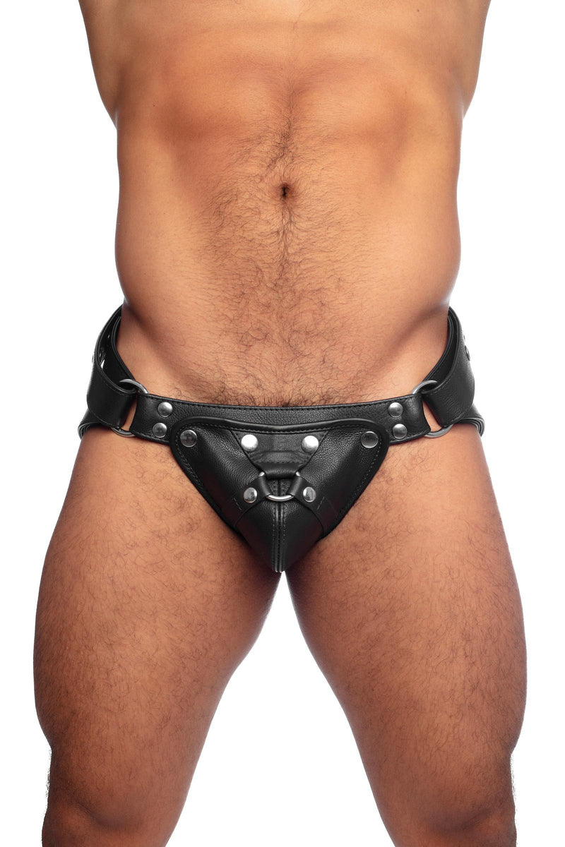 Model wearing a black leather harness jockstrap with stainless steel hardware. Front view.