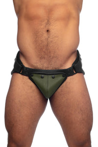 Muscular model in a black leather jock with army green codpiece. Front view.