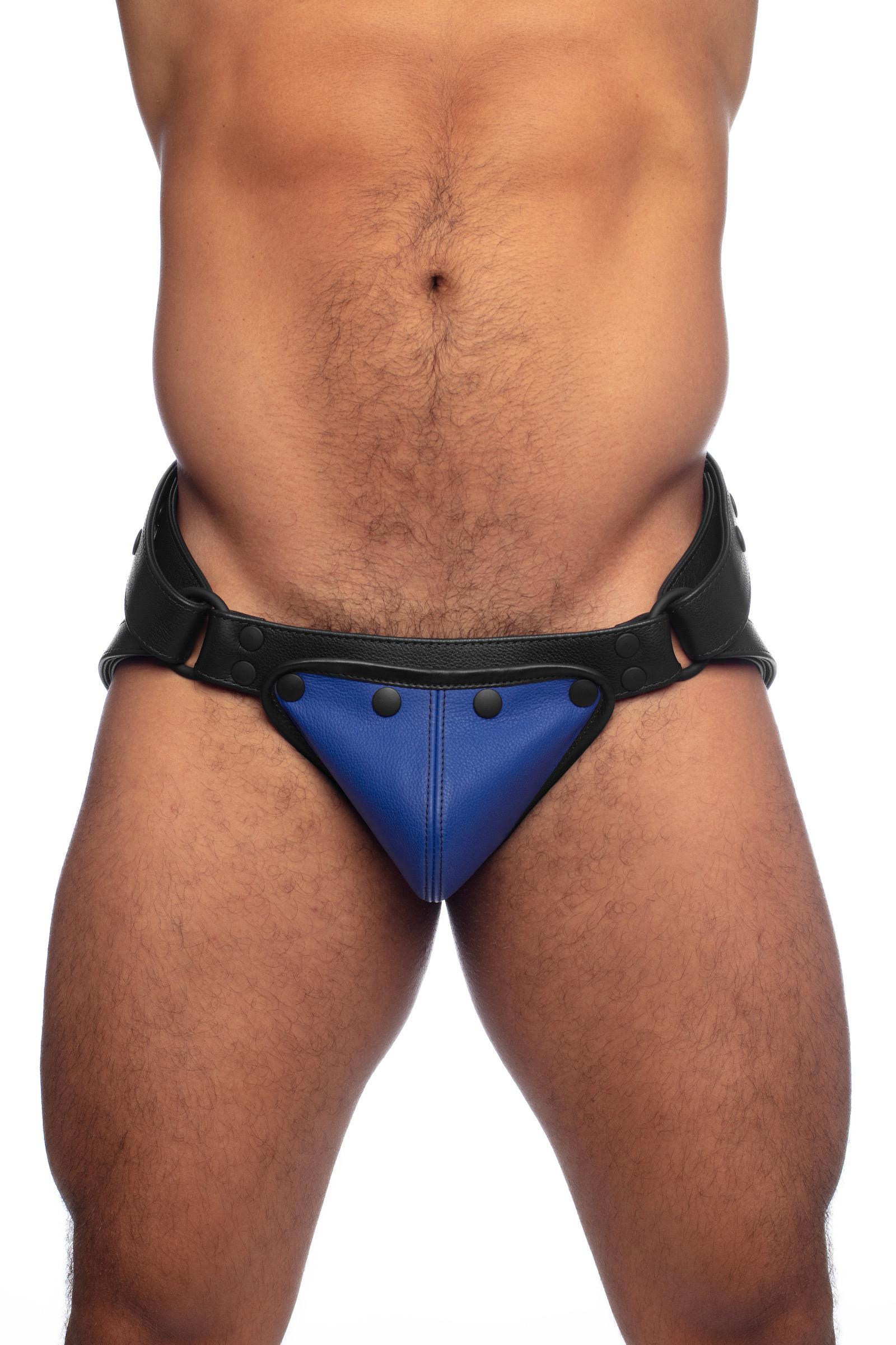 Thick model in a black leather jockstrap with blue codpiece. Front view.