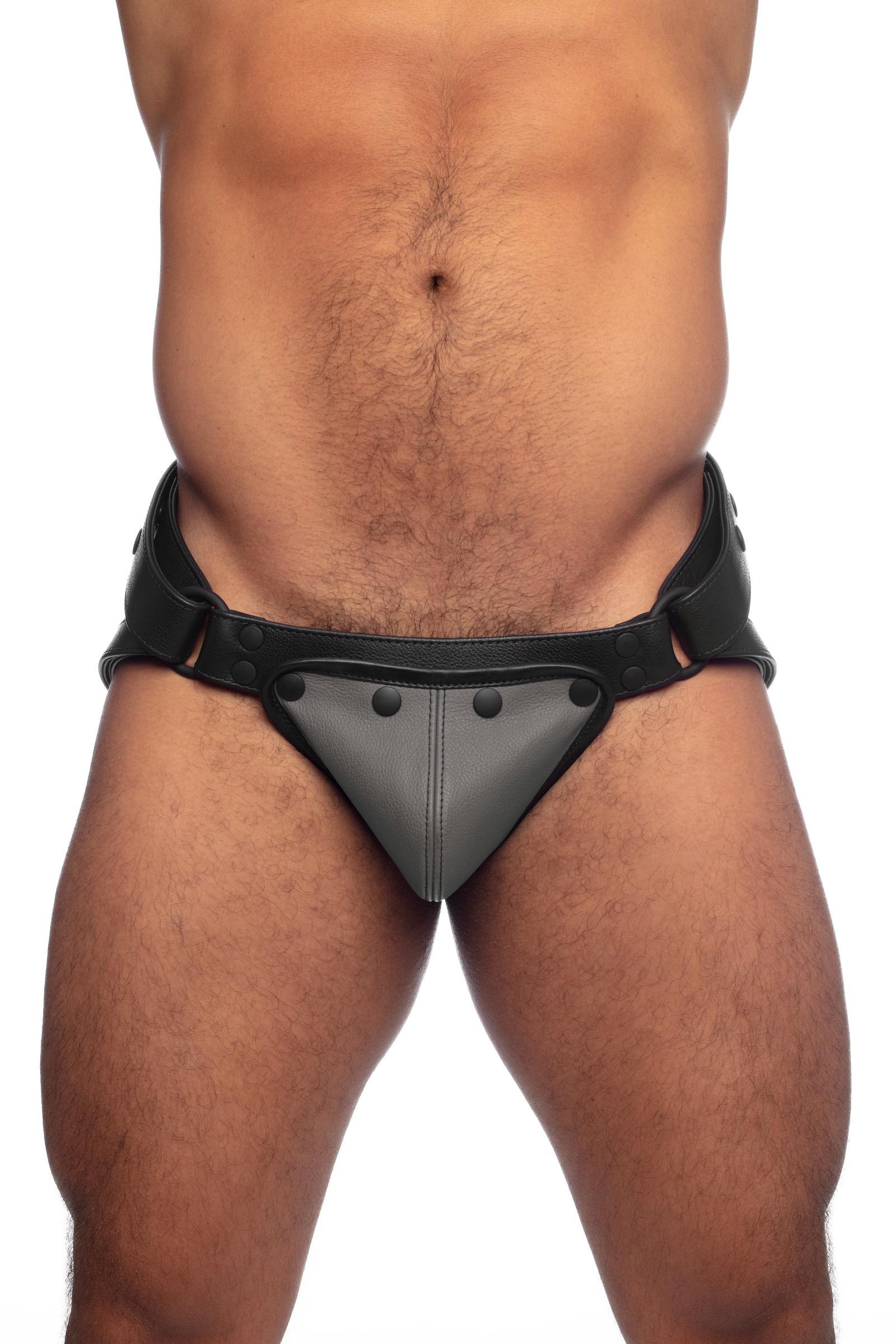 Front view of a male model in a black leather jockstrap with grey leather codpiece.
